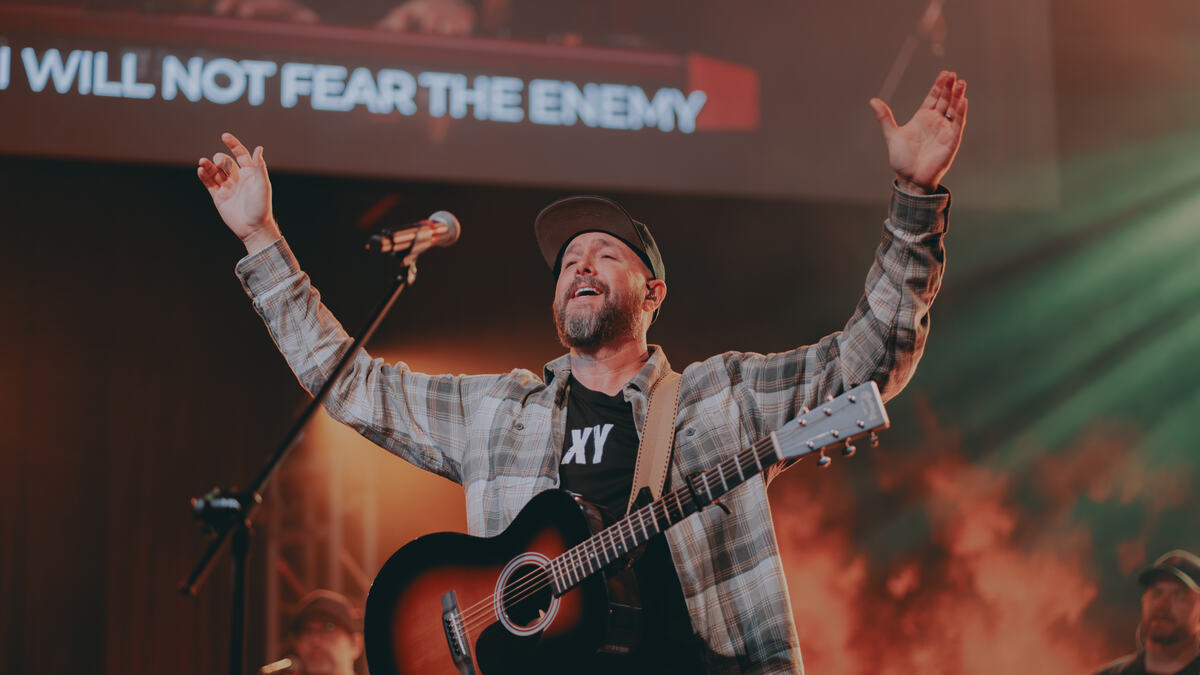 Worship leader with guitar on stage
